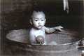 B&W picture of Janchang as a baby in a wooden bathtub